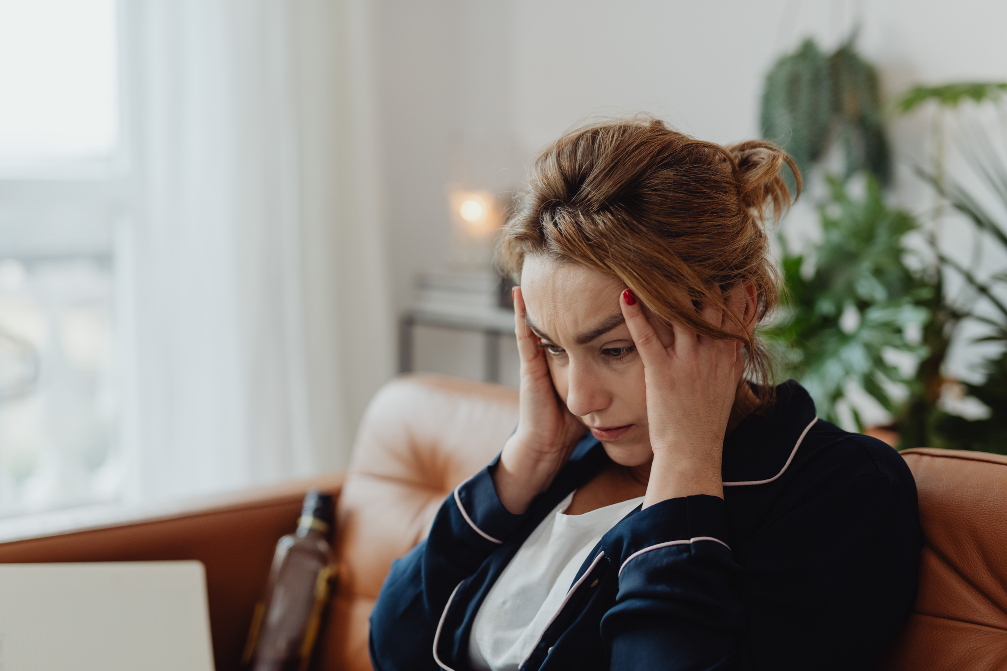 Woman Wearing a Pajama Holding Her Head