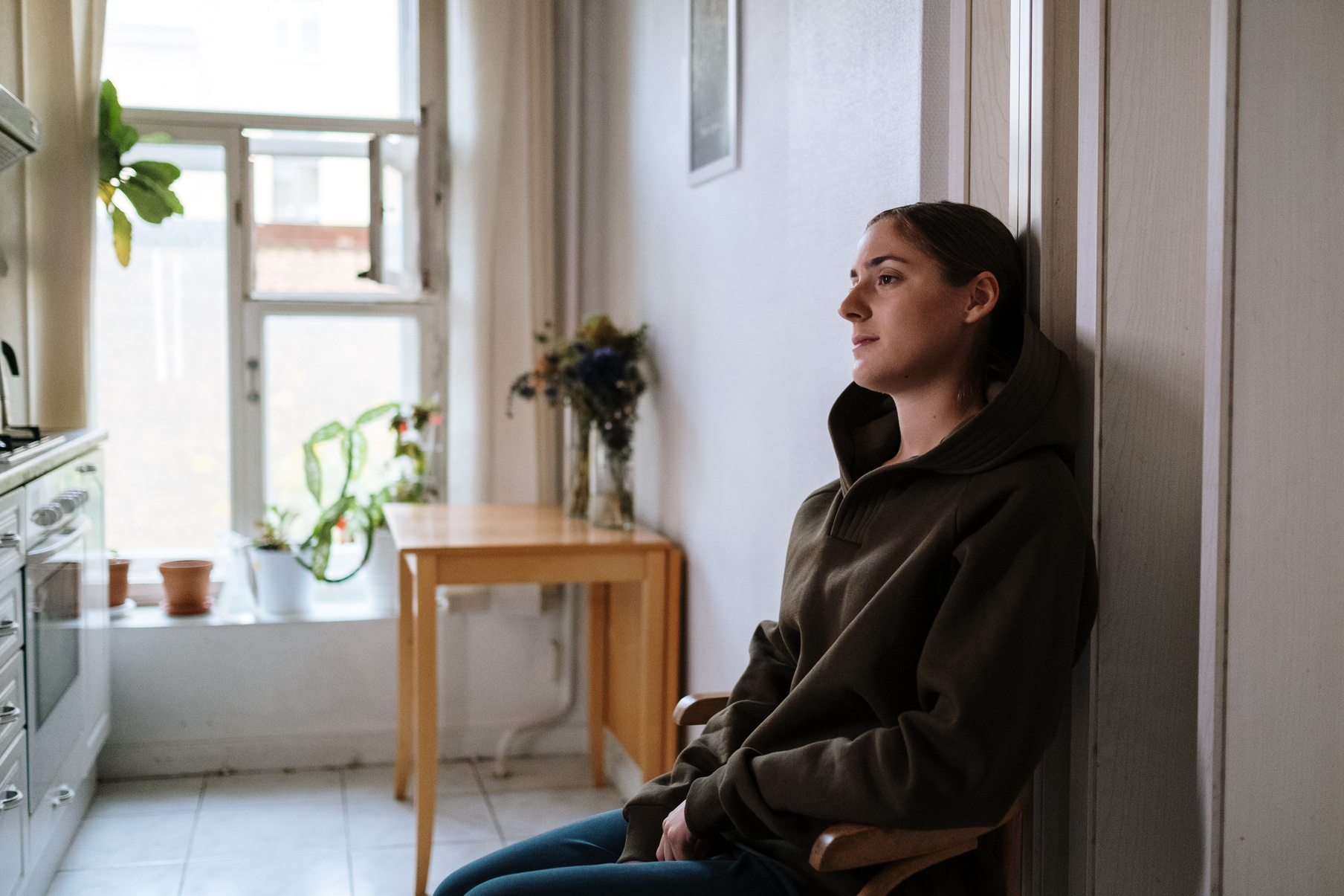 Photograph of a Woman in a Hoodie Sitting